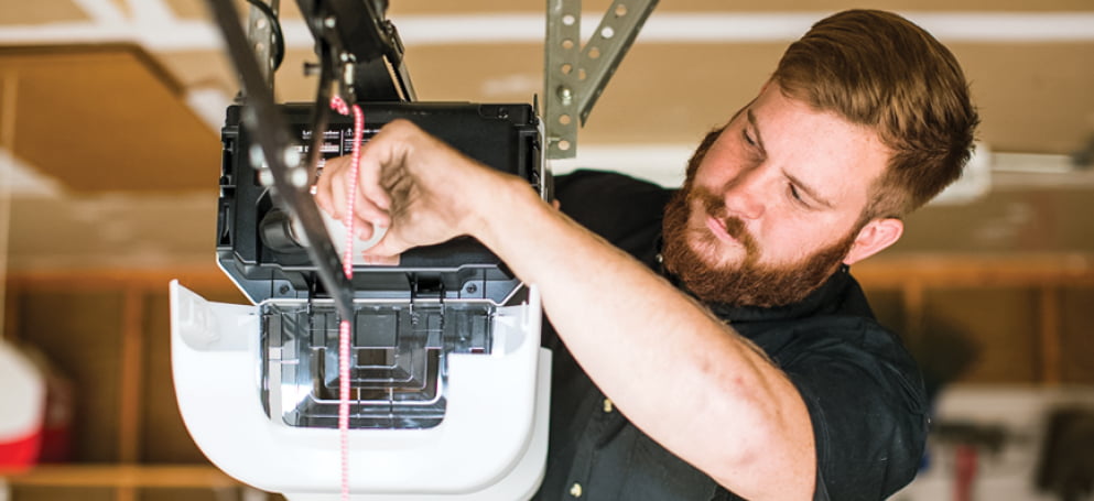 Two repair men fixing a garage door