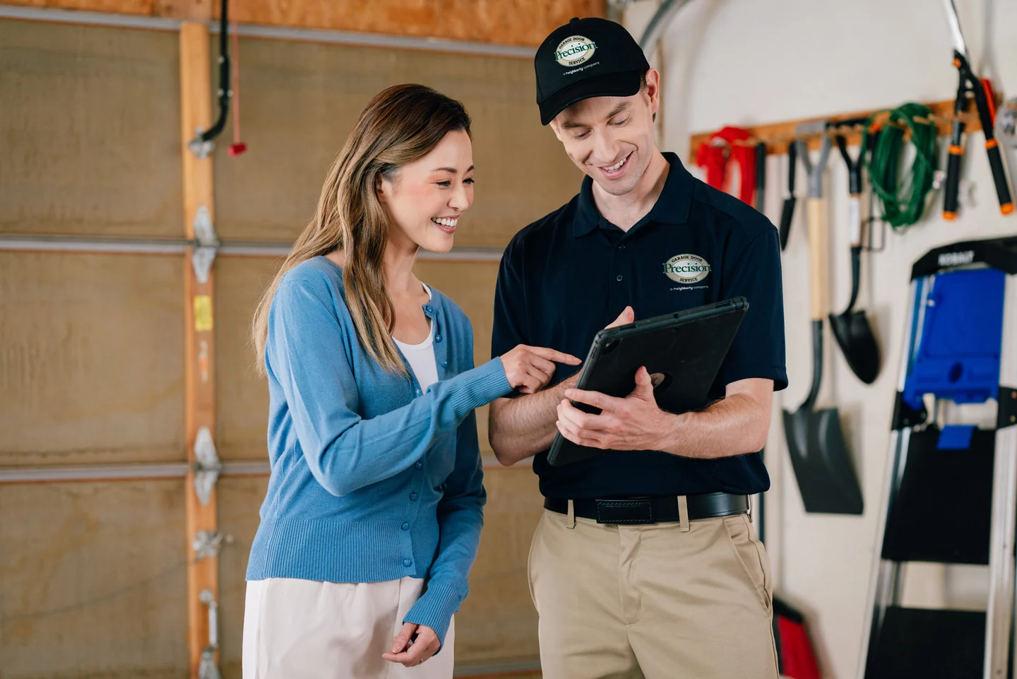 Precision Garage Door repair technician with a customer