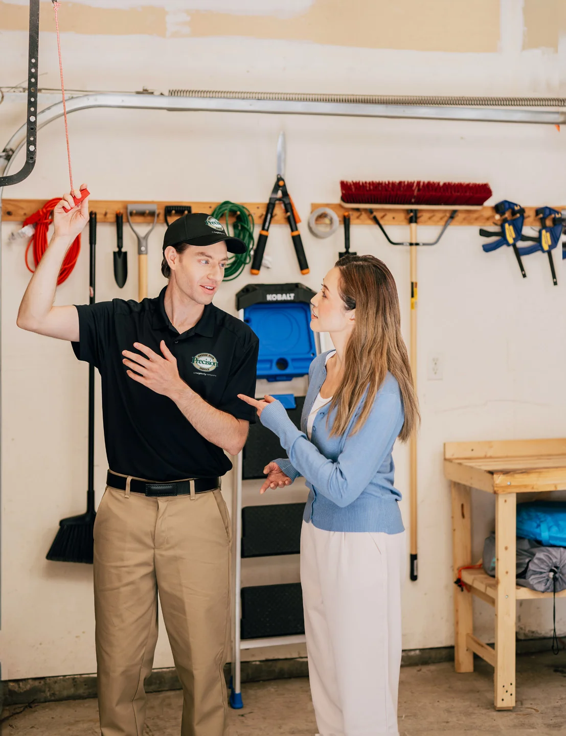 Precision Garage Door technician showing customer how to use the emergency release cord